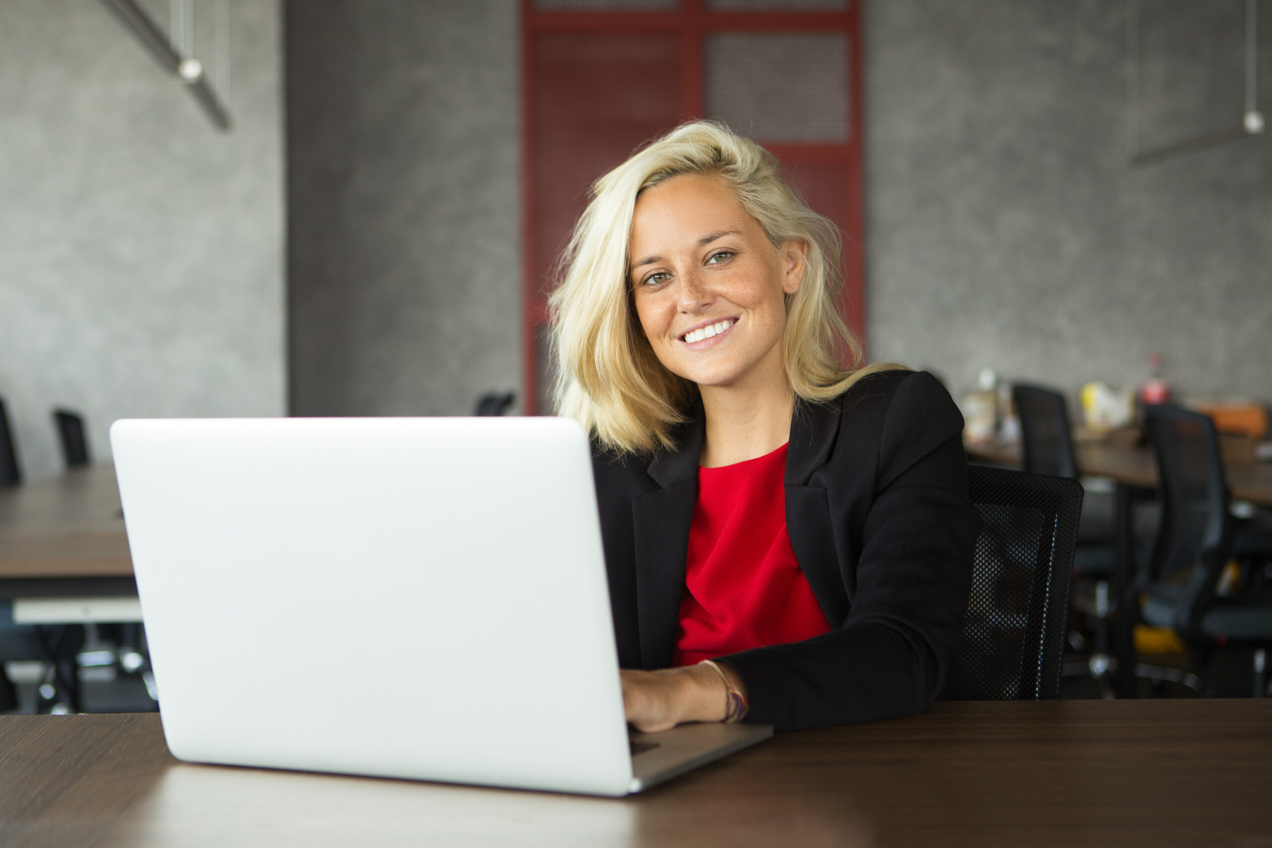 Smiling young businesswoman working at laptop